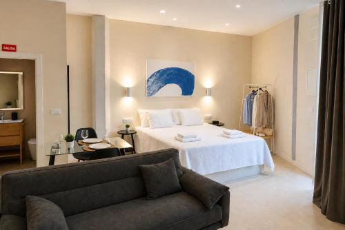 a hotel room with a bed and a couch at Roca Collection MSuites in Valencia