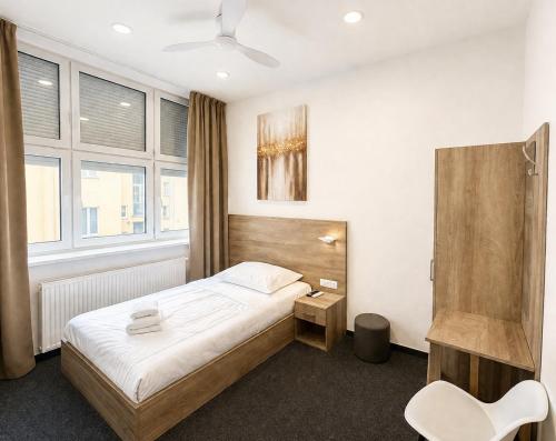 a bedroom with a bed and a chair in it at Rabie Aparthotel in Prague