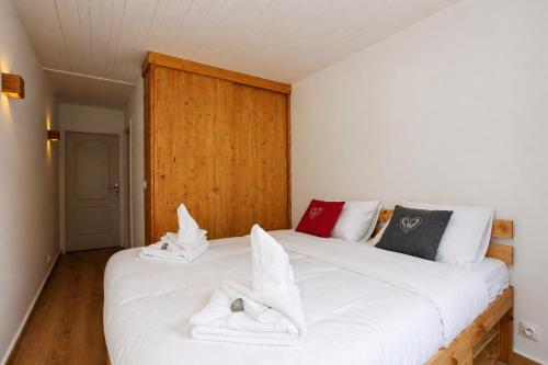 a bedroom with a large white bed with towels on it at Superbe T3 en face du Brevent, Chamonix in Chamonix