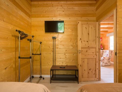 a bedroom with wooden walls and a tv on the wall at Rustic Home By CanariasGetaway in Telde