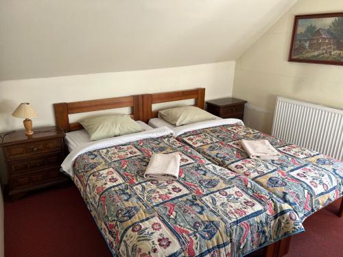 a bedroom with a large bed with a colorful quilt at GASTHAUS SCHLUCKENAU in Šluknov