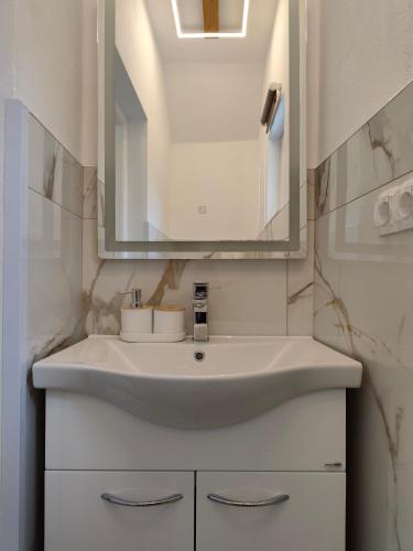 a bathroom with a white sink and a mirror at Guest House Bee in Visoko