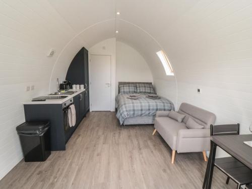 a room with a bed and a couch and a table at Natures Nest in Malton