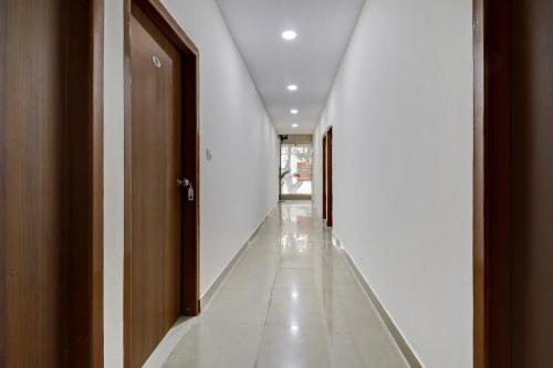 an empty hallway with white walls and a door at Hotel O Maruthi Paradise Netaji Udyanavana Park in Bangalore