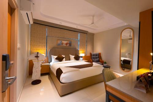 a hotel room with a bed and a mirror at Dlite Rivera Premium Hotel Apartments in Bangalore