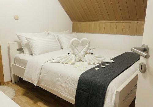 a bedroom with a white bed with a black blanket at Residence La Femme in Tuzla