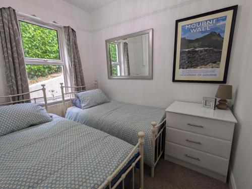 a bedroom with two beds and a mirror and a window at Lough View in Rostrevor