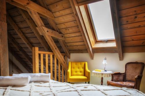 a bedroom with a bed and a yellow chair at ZielonoMi-Zielonowo in Zieleniak