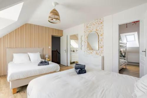 a white bedroom with two beds and a mirror at Grande maison familiale centre ville - 2km des plages in Beaussais sur Mer