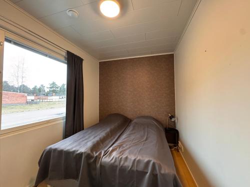 a bed in a room with a window at Kotimaailma - Saunallinen kolmio in Kokkola