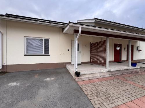 a house with a garage and a driveway at Kotimaailma - Saunallinen kolmio in Kokkola