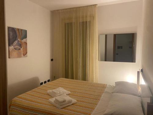 a bedroom with a bed with two towels on it at Luca's Home in Villongo SantʼAlessandro