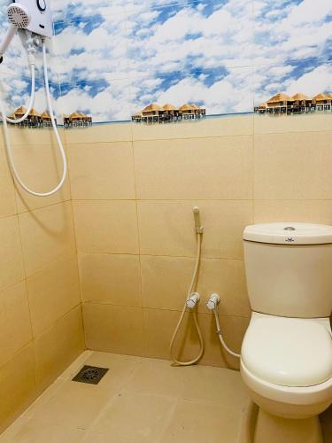 a bathroom with a toilet and a shower with umbrellas at Baywings Rooms in Arugam Bay