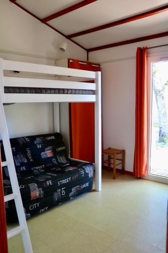 a bedroom with two bunk beds and a window at Chalet Au Petit Bonheur Piscine & Domaine calme in Rivières