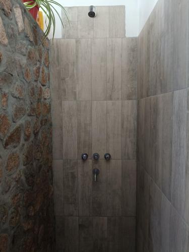 a bathroom with a shower with a stone wall at El Aromo Cafayate in Cafayate