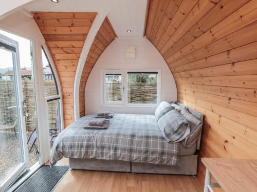a bedroom with a bed in a room with wooden walls at Cosy Cocoon in Malton
