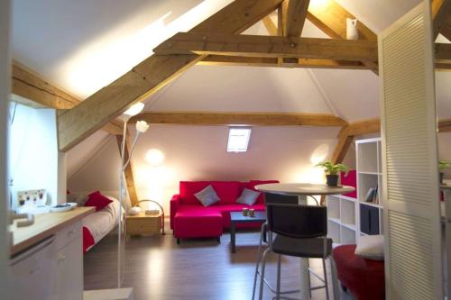 ein Wohnzimmer mit einem roten Sofa und einem Tisch in der Unterkunft Morges House in Morges