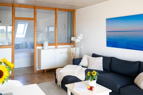 a living room with a blue couch and a kitchen at Sonnenkoje in Fehmarn