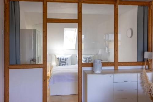 a bedroom with a white bed and a glass wall at Sonnenkoje in Fehmarn