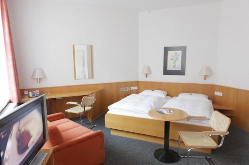a hotel room with a bed and a tv at Hotel Berliner Hof by Coffee Fellows Hotels in Kiel