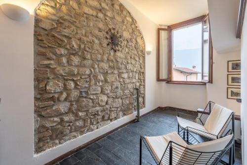 a room with chairs and a stone wall at Historic Borgo Lake Como Campidoglio 5 in Lenno