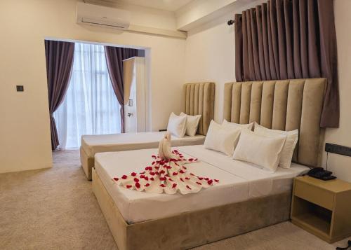 a hotel room with a bed with red roses on it at Kings hotel in Colombo