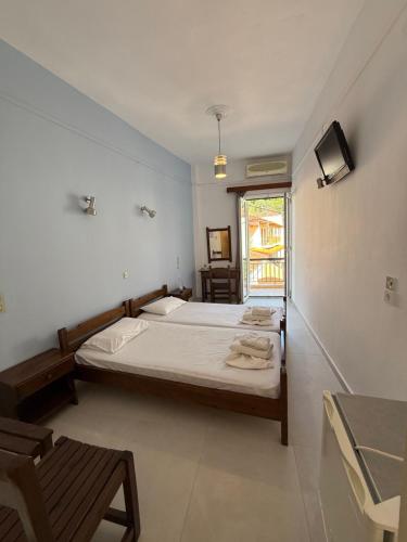 a bedroom with a bed and a tv and a window at Hotel Galini in Parga