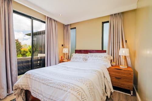 a bedroom with a bed and a large window at Oaklands Tin Nest in Ruiru