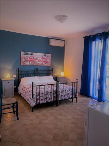 a bedroom with a bed and blue walls at Agriturismo dal Pastore in Follonica