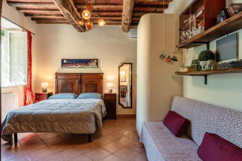 a bedroom with a bed and a couch at Casa Anita Lucca in Lucca