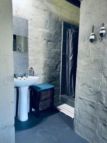 a bathroom with a white sink and a shower at Emoyeni Eco Lodge in Sodwana Bay
