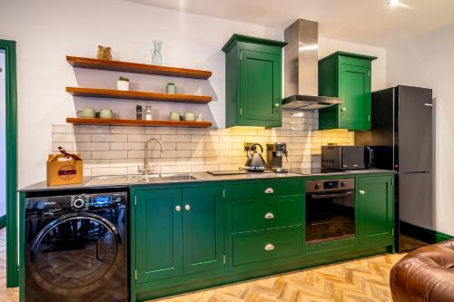 a kitchen with green cabinets and a dishwasher at Tawny Lodge in York