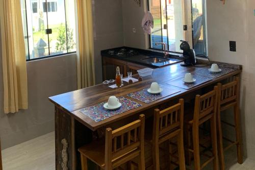 a kitchen with a large wooden island with two chairs at Pousada Mar Vintage in Laguna
