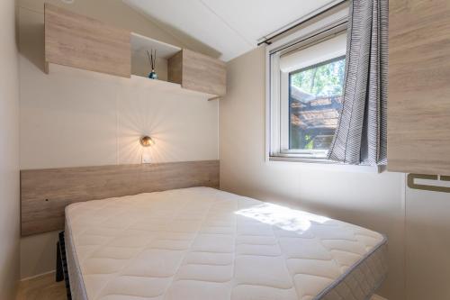 a small bedroom with a bed and a window at Gassin bungalow in Gassin