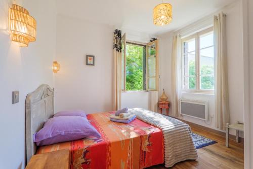a bedroom with a bed and a large window at Gite en sud-ardèche avec jacuzzi in Joyeuse