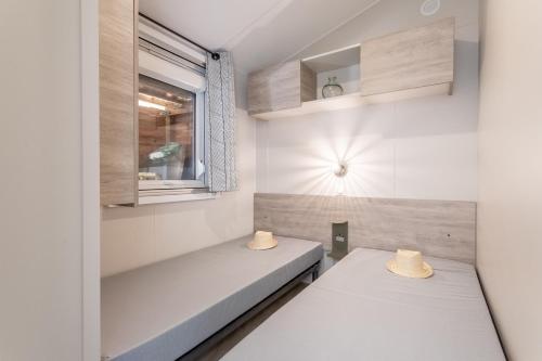two beds in a small room with a window at Gassin bungalow in Gassin