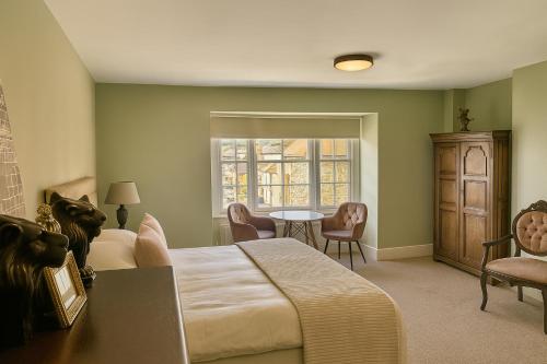 a bedroom with a bed and a table and chairs at The Lion Hotel in Builth Wells