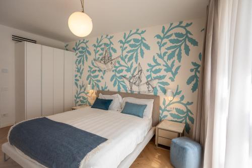 a bedroom with a bed with blue and white wallpaper at Marina di Scarlino Follonica Vista Mare in Puntone di Scarlino
