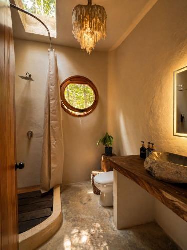 a bathroom with a toilet and a sink and a chandelier at Selva Morena in Felipe Carrillo Puerto
