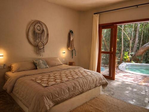 a bedroom with a bed and a swimming pool at Selva Morena in Felipe Carrillo Puerto