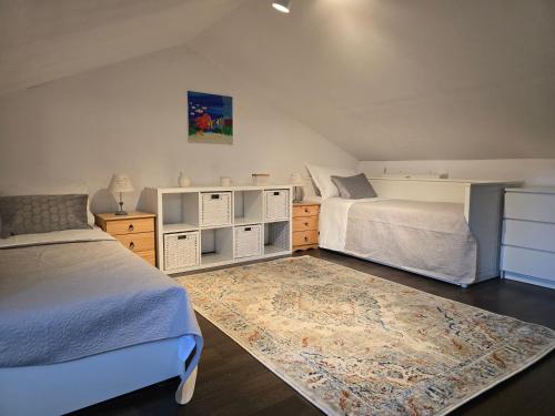 a bedroom with two beds and a rug at Artisana Silba in Silba