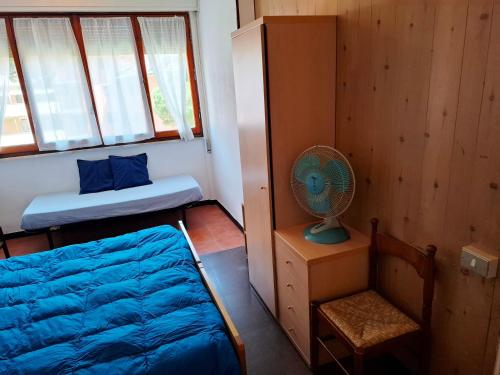 a small bedroom with a bed and a fan at Albergo La Lampara in Deiva Marina