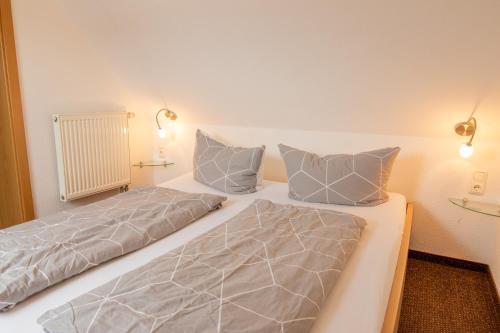 a bed with two pillows on it in a room at Holiday Home Blu Hus in Freest