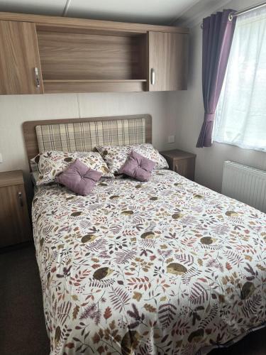 a bedroom with a bed with a comforter and pillows at Swift Bordeaux 56 in Dunoon
