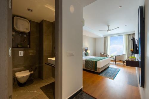 a hotel room with a bed and a bathroom at The Lohias Premium - Delhi IGI Airport in New Delhi
