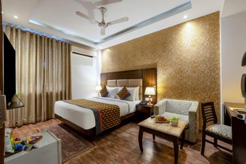 a hotel room with a bed and a chair at The Lohias Premium - Delhi IGI Airport in New Delhi
