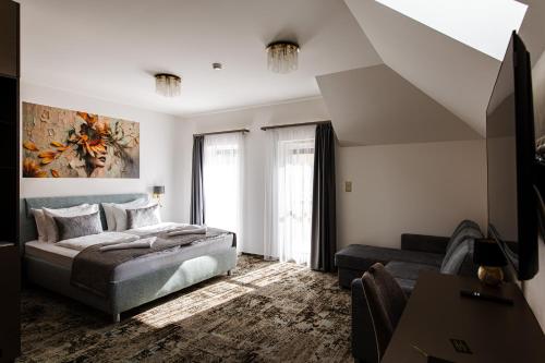 a bedroom with a bed and a couch at KQC Boutique Villa in Balatonlelle