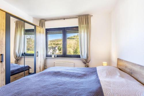 a bedroom with a bed and a large window at Ferienwohnung Landblick in Brilon