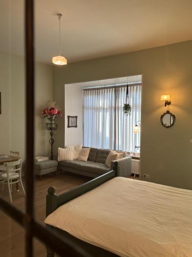 a bedroom with a bed and a living room at Appartement 'de Stadstuin' in Harderwijk
