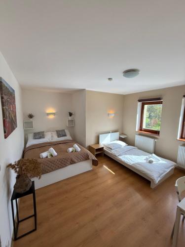 two beds in a room with wooden floors at pension N.10 in Frymburk